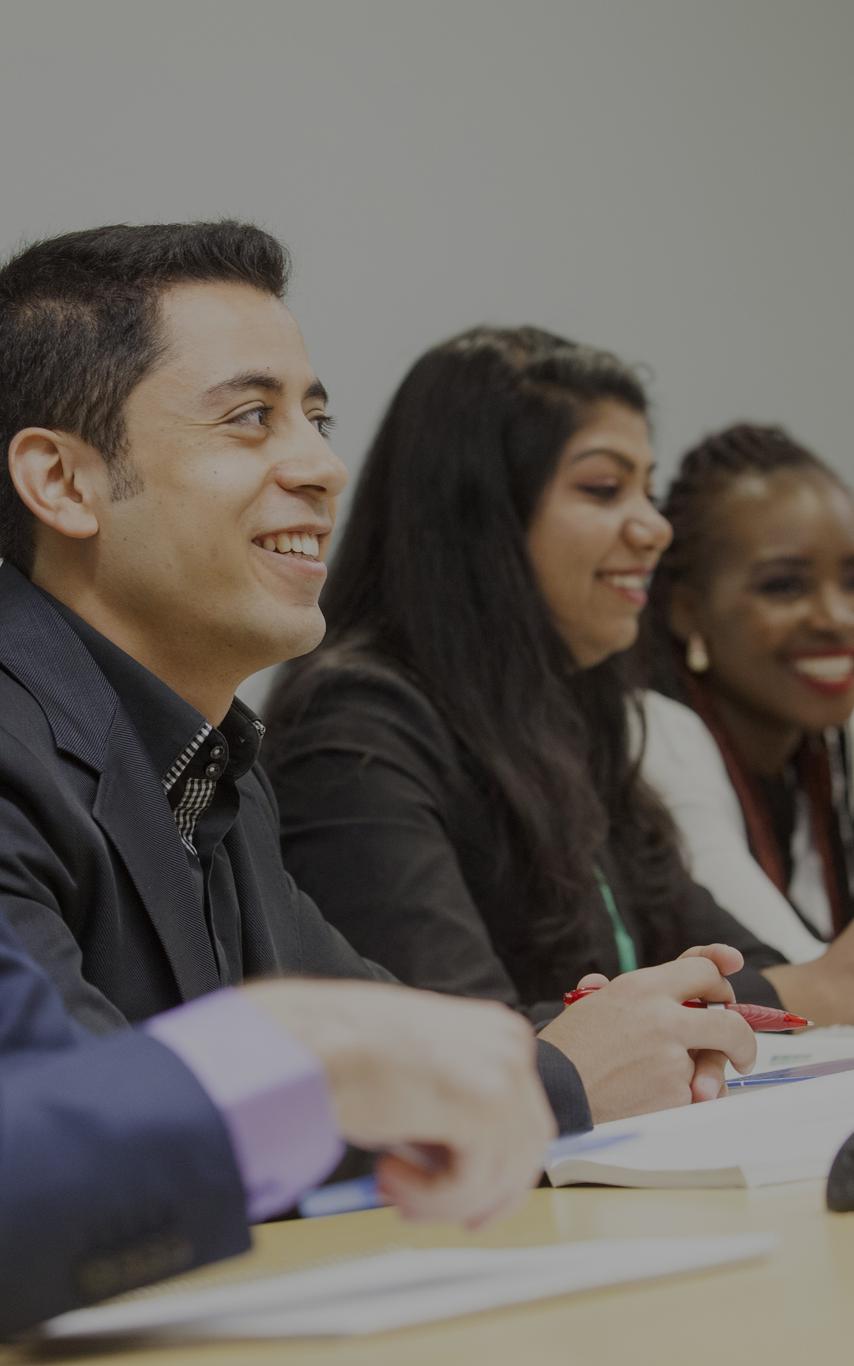 A divers group of 5 students angled along a table 
